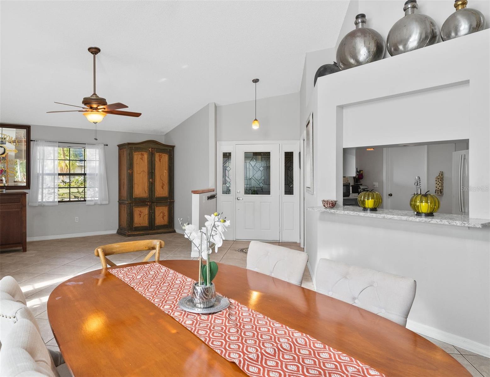 View from dining room looking at the living room, front door and kitchen pass through window.