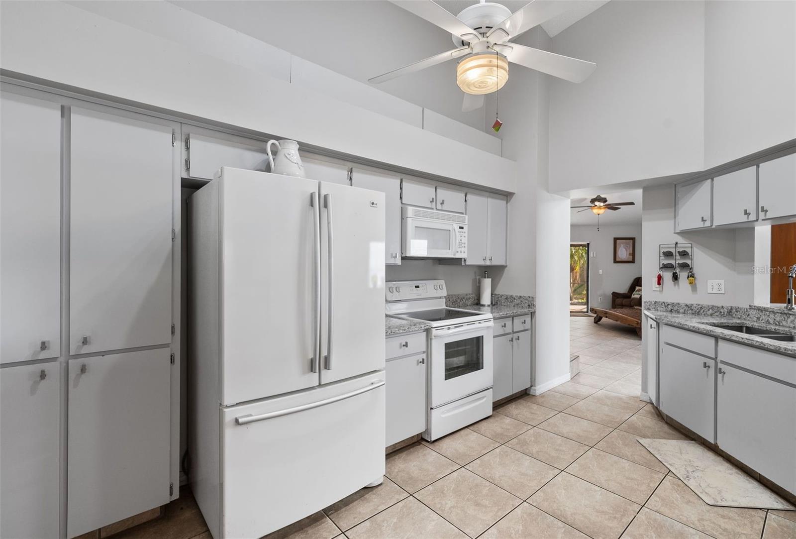 View of kitchen with ample quartz countertops and storage.