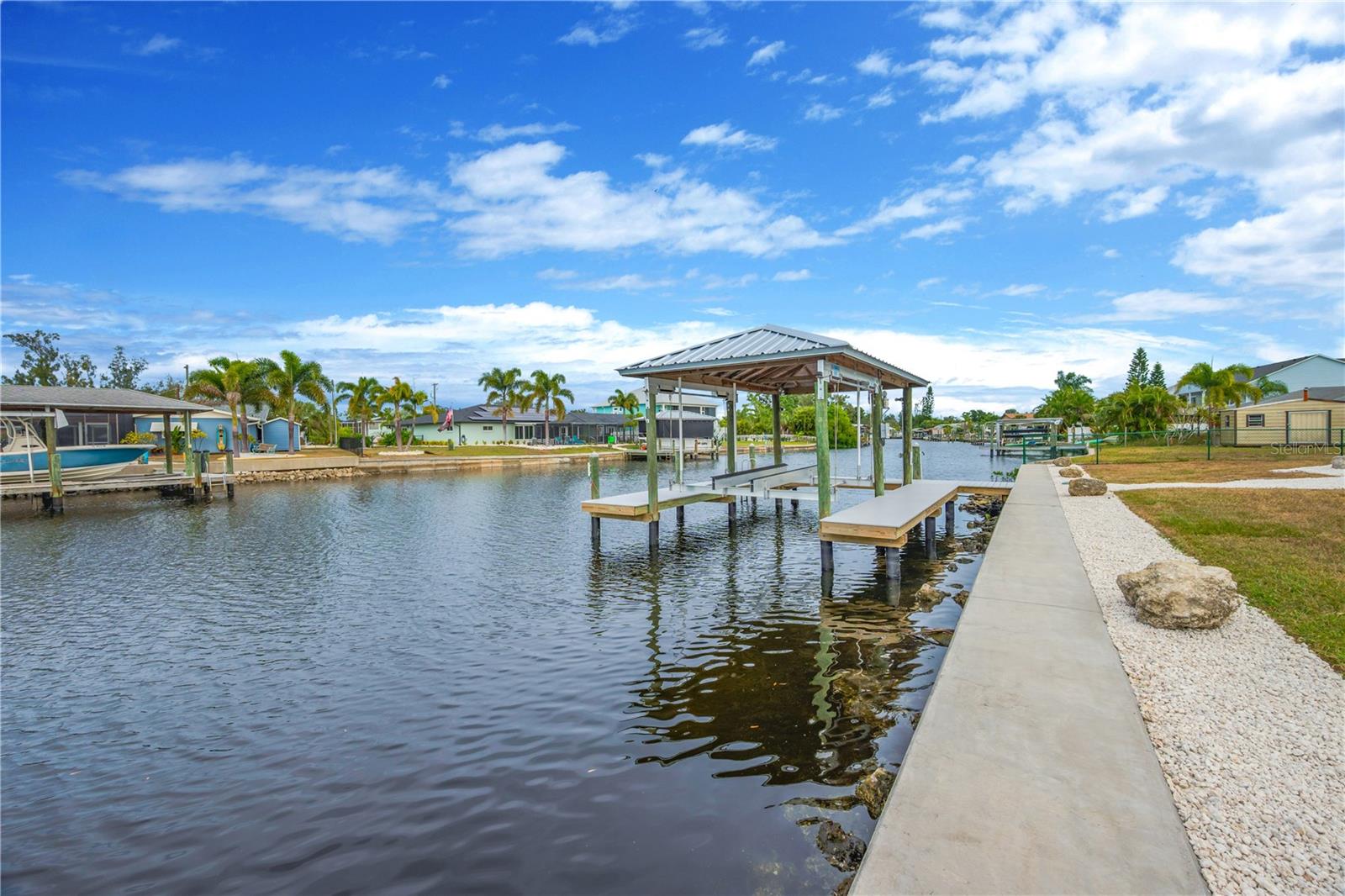 The recently constructed covered boathouse and dock, complete with a powered boat lift, water, and electricity, can accommodate a boat up to 26'.