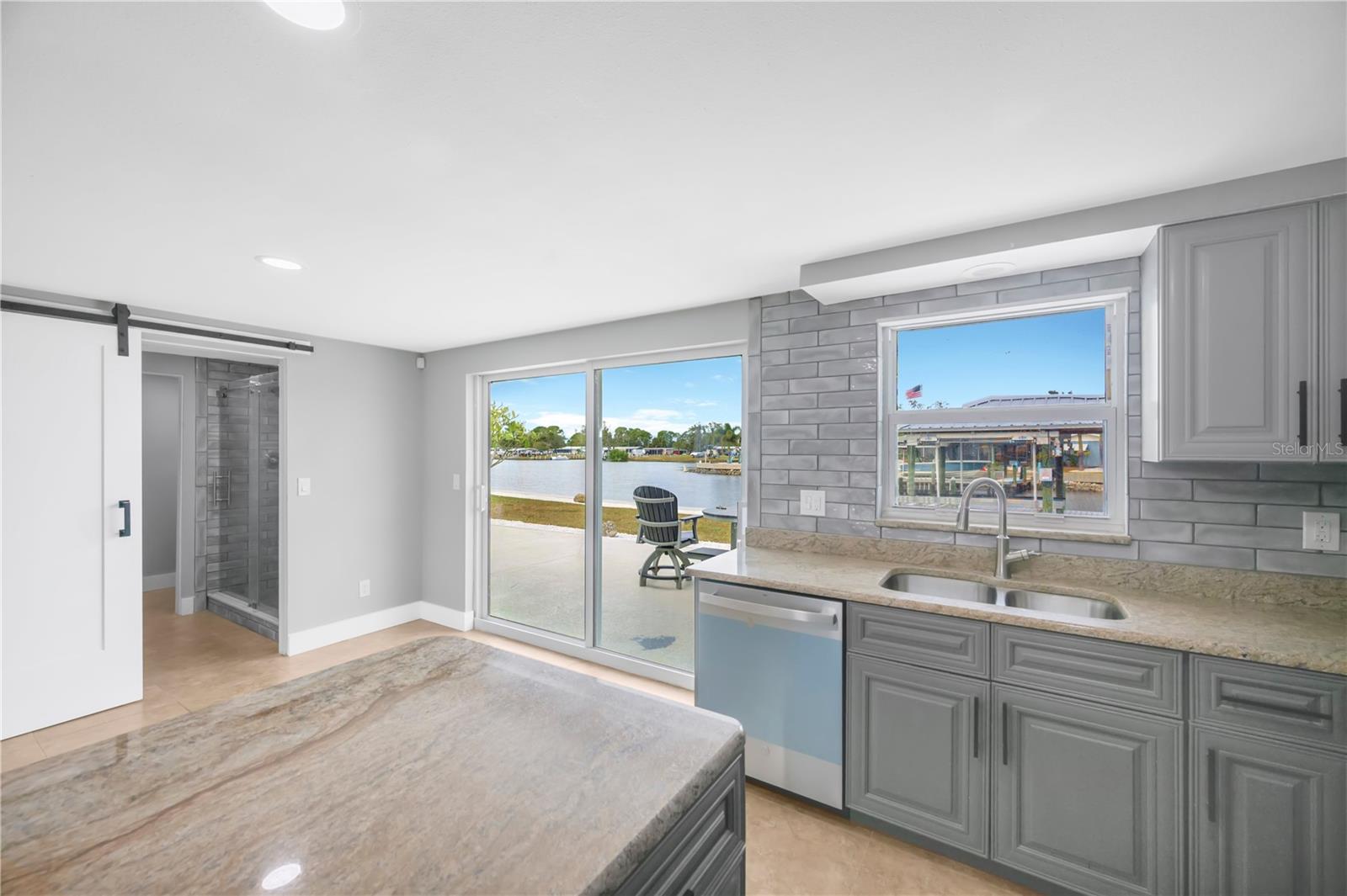 Granite counters, stunning water views and eat-in area by sliders.  Barn door leads to a full bathroom and inside laundry room.