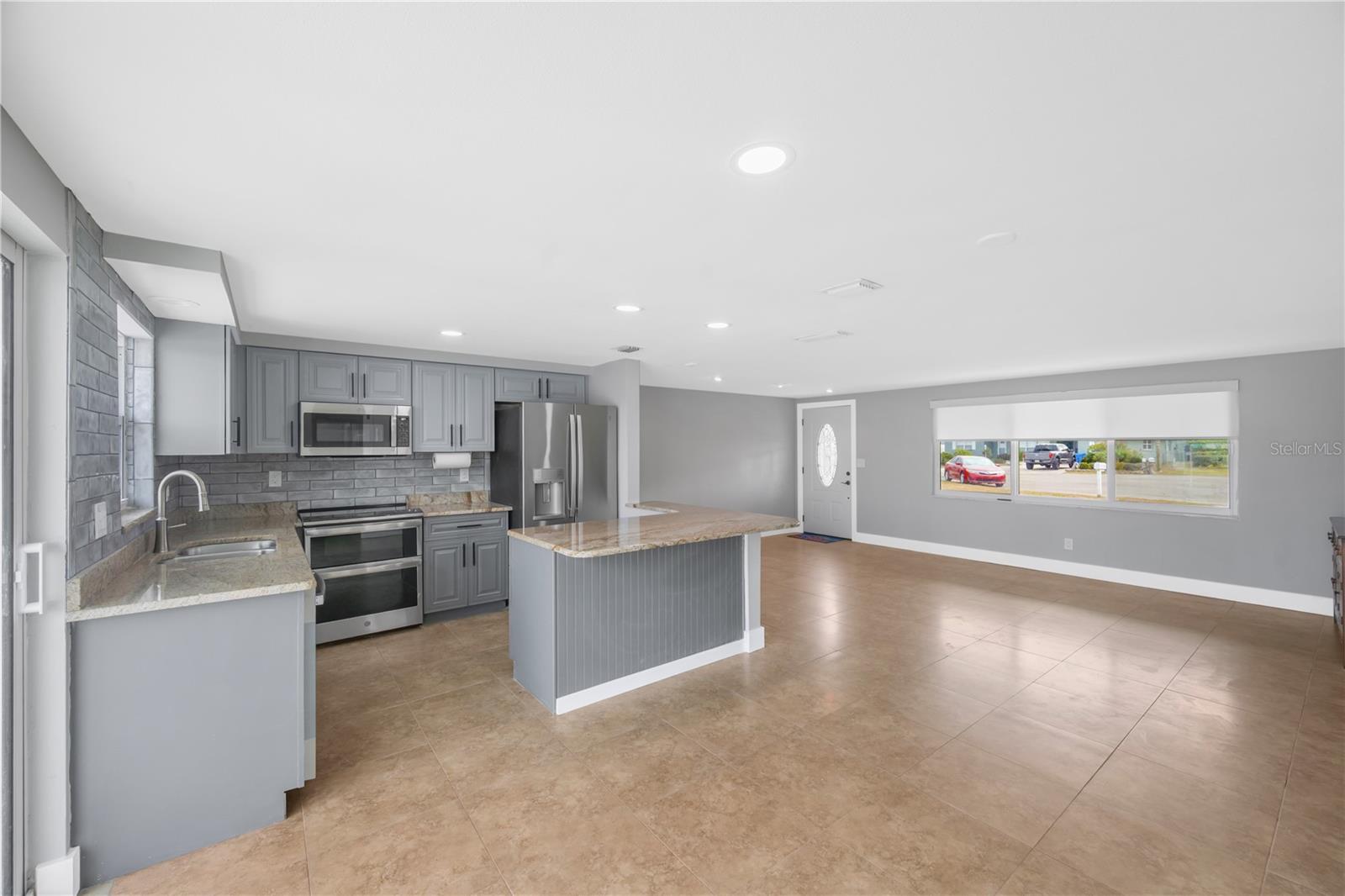 The living room has a seamless connection to the kitchen and casual dining area.