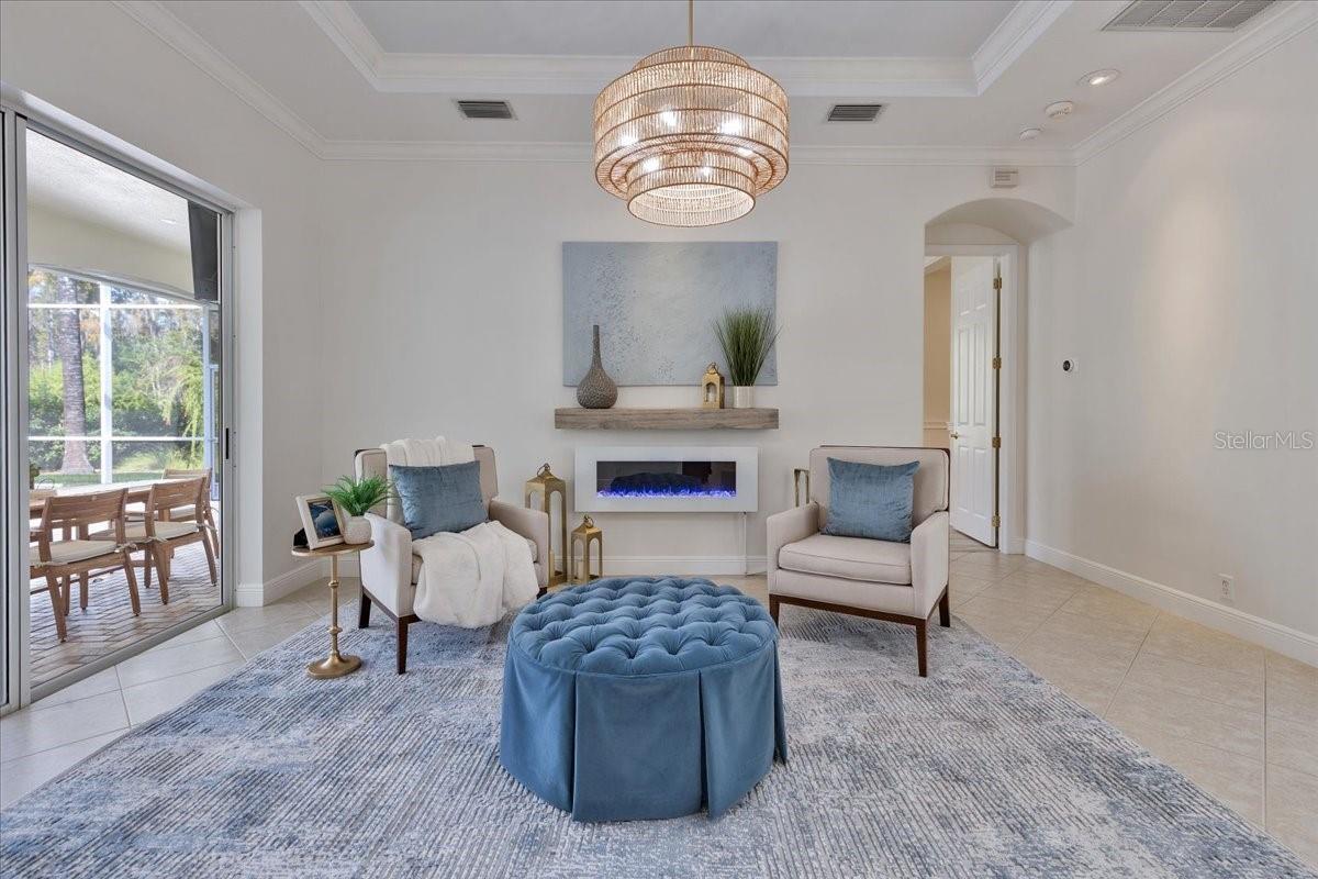 Formal Living Room with Access to Lanai and Decorative Electric Fireplace and Mantle