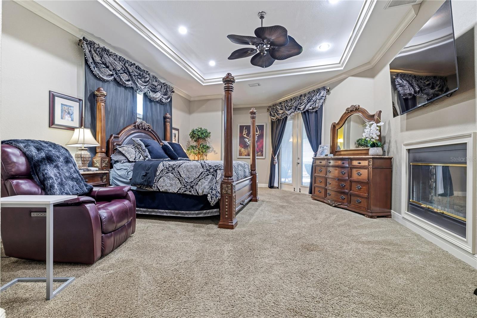 Primary Bedroom with Tray Ceiling and Fireplace