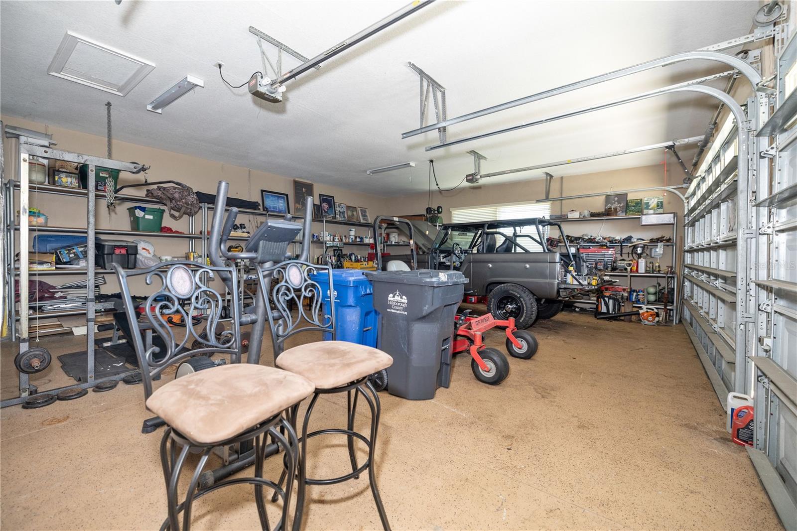 3 car garage with shelving and storage area.