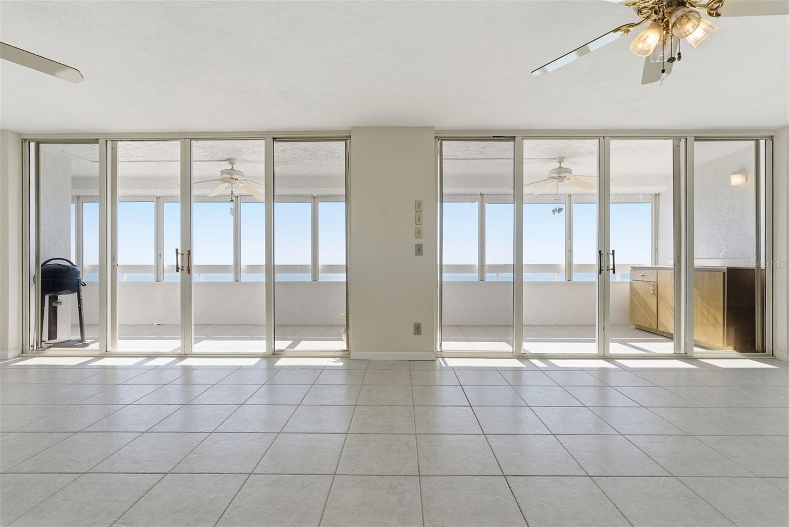 Bright, wide-open living space seamlessly connected to the enclosed balcony.