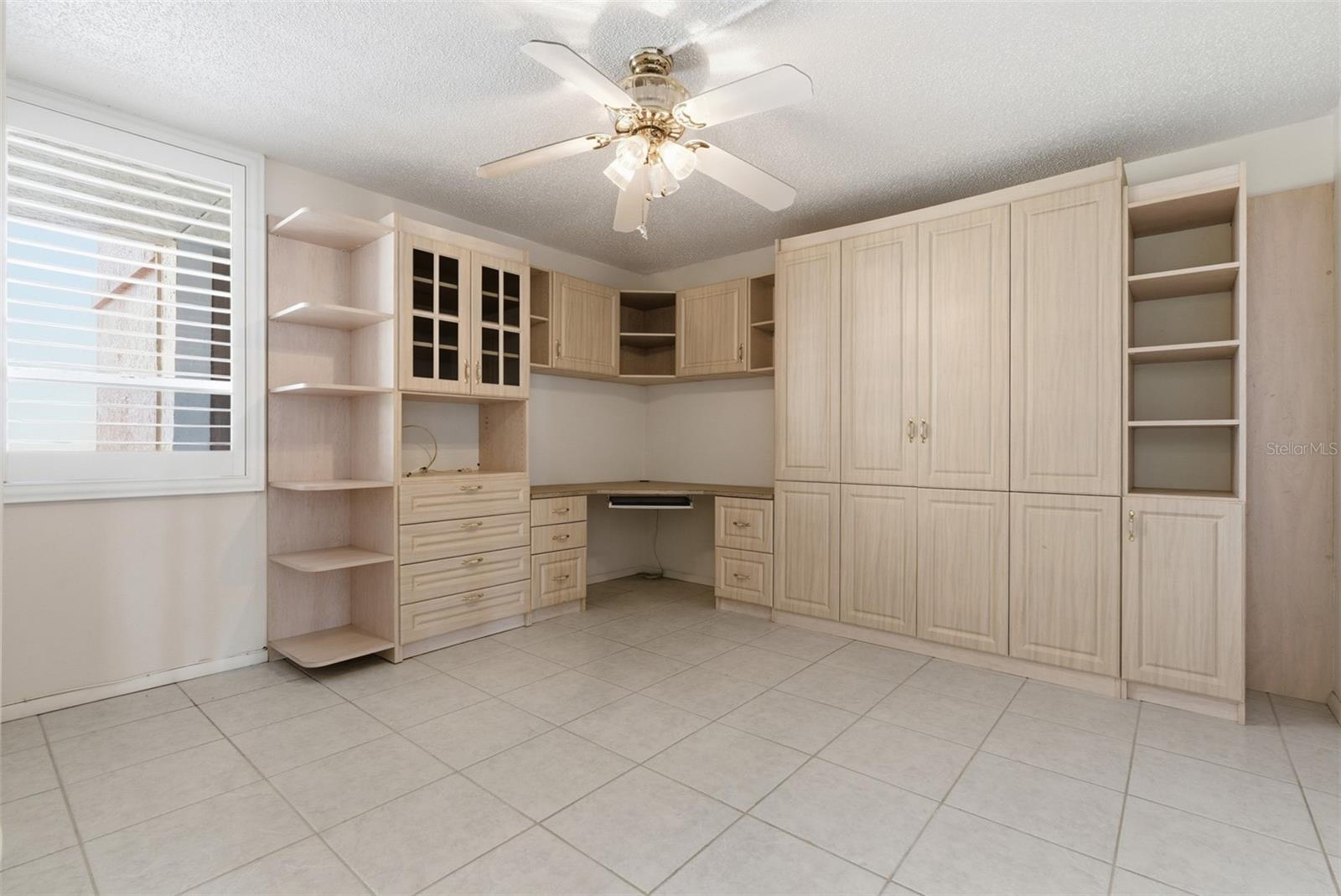 Third bedroom with custom built-in desk and cabinetry, a pull-out Murphy bed, and a generous walk-in closet—ideal as a home office, guest room, or both.