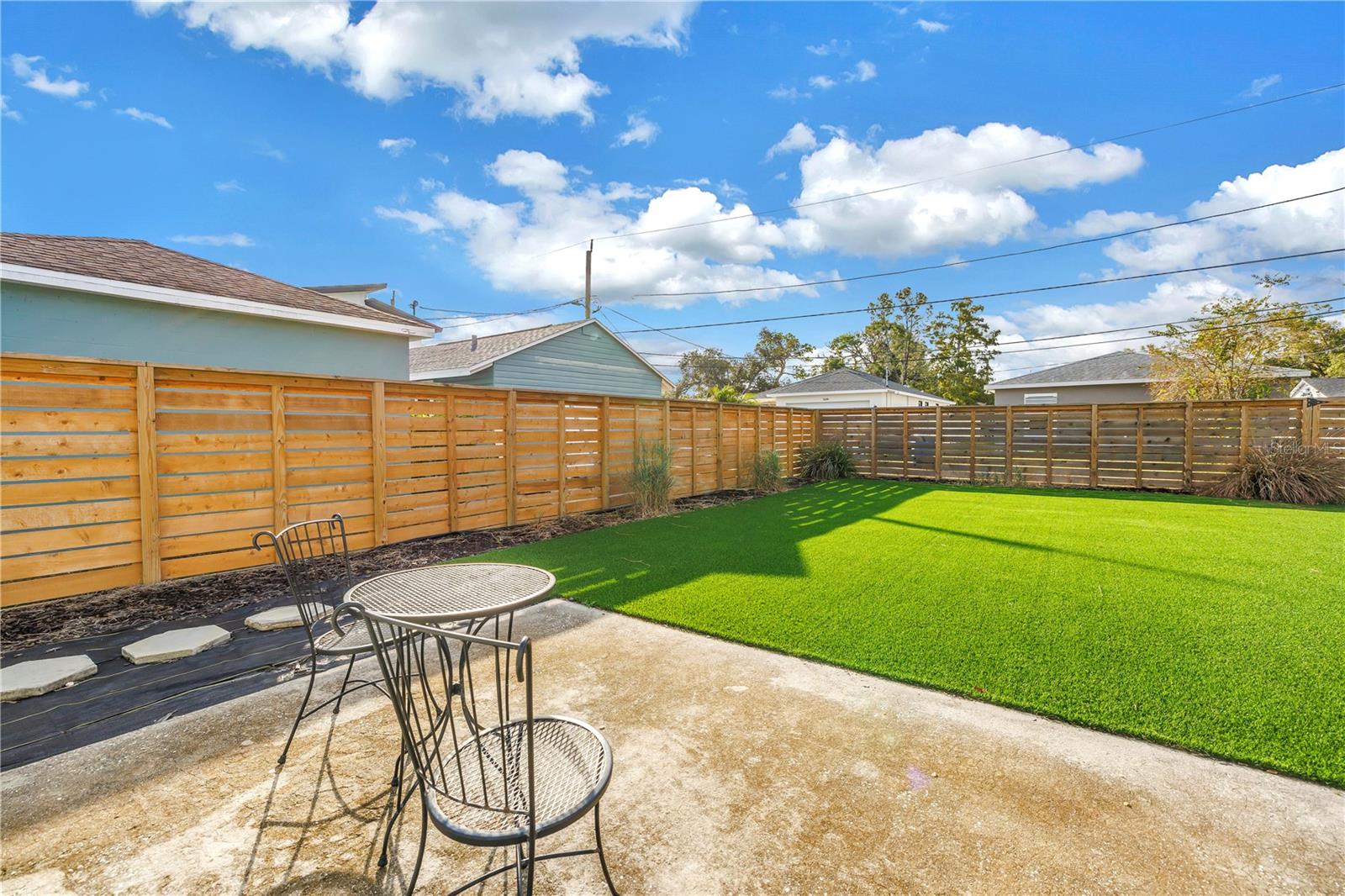 Back yard with field turf and professional landscaping.