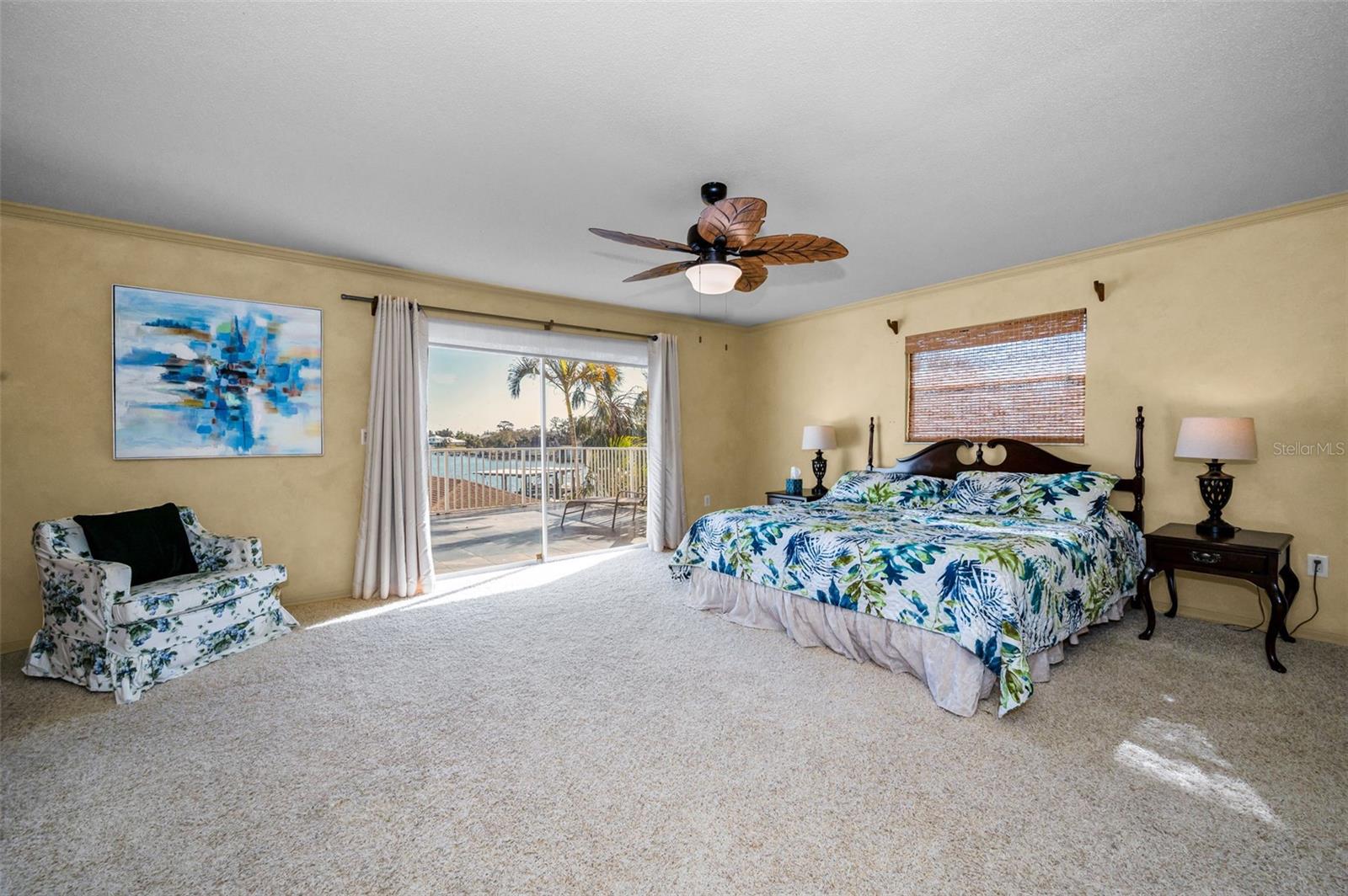 Primary, view of River, sliders open to expansive balcony.