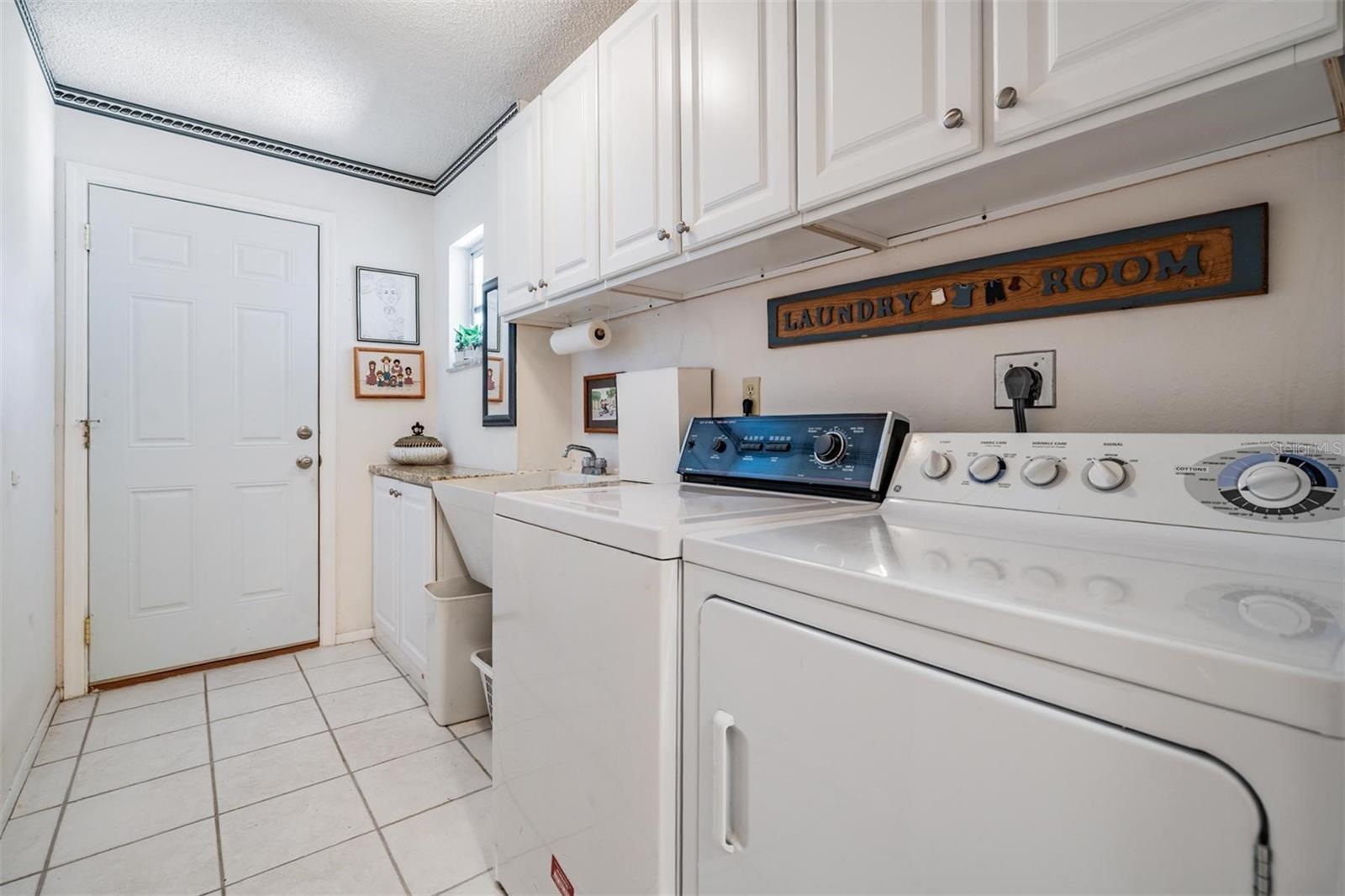 Walk-in laundry room with utility sink and many built-ins