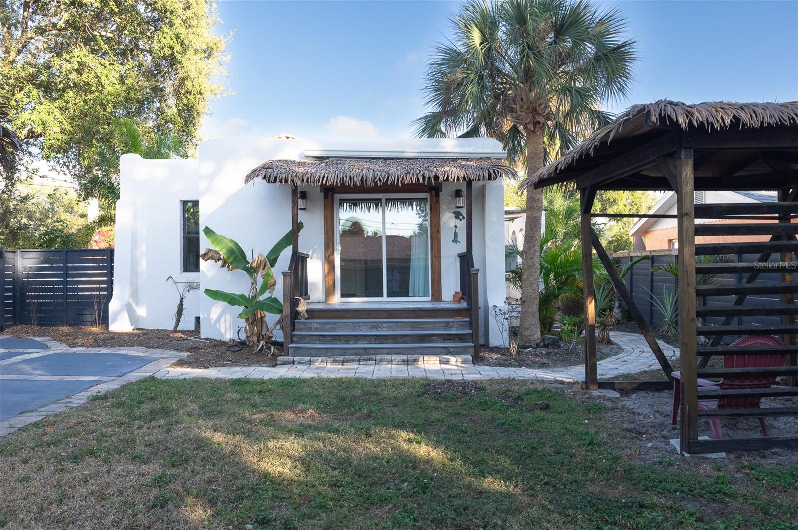Private porch off primary bedroom with backyard and cabana seating area