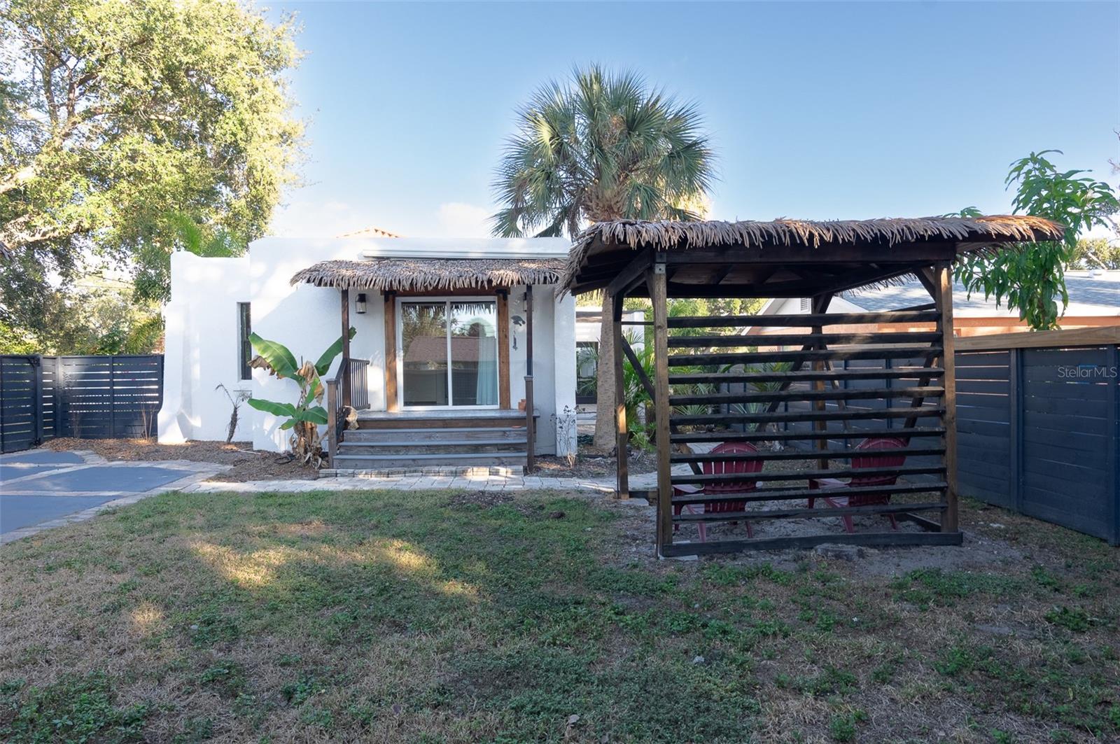 Private porch off primary bedroom with backyard and cabana seating area