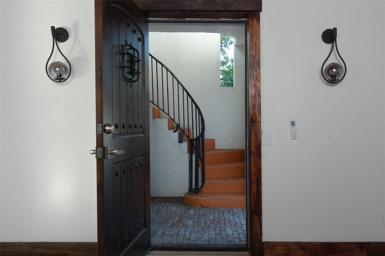 Front door from the living room looking at outdoor entryway and stairway to private rooftop terrace