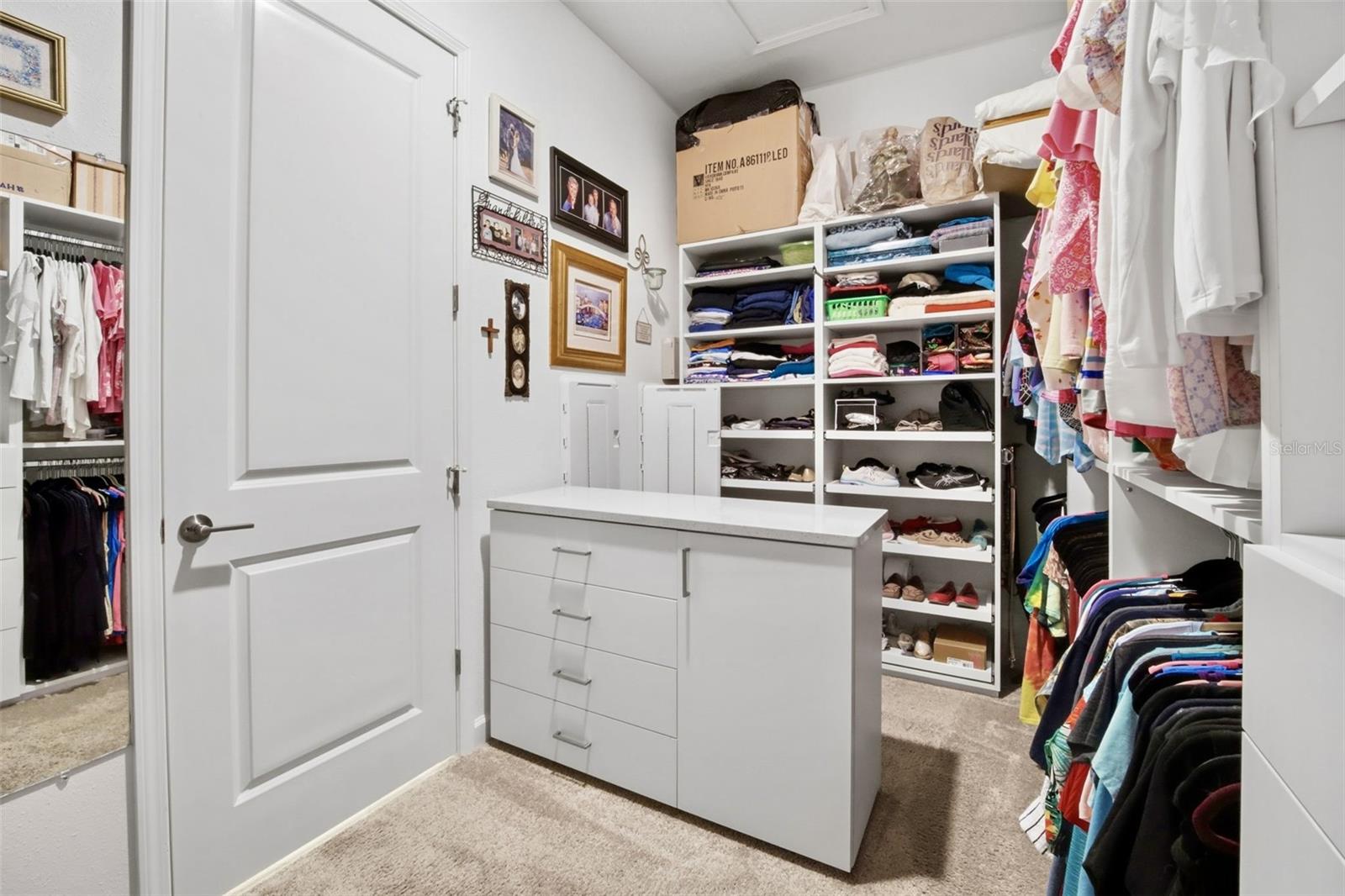 Custom closet organizers and center island in the large owners closet