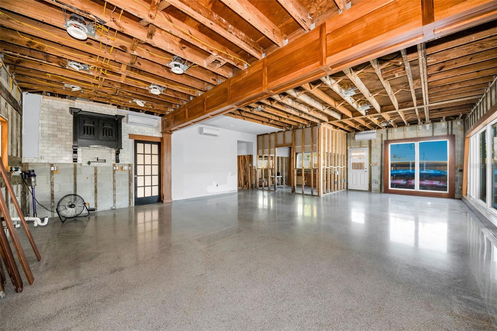 Open concept kitchen, dining, and living areas with soaring 9.5 foot ceilings surrounded by picture windows for abundant natural light.