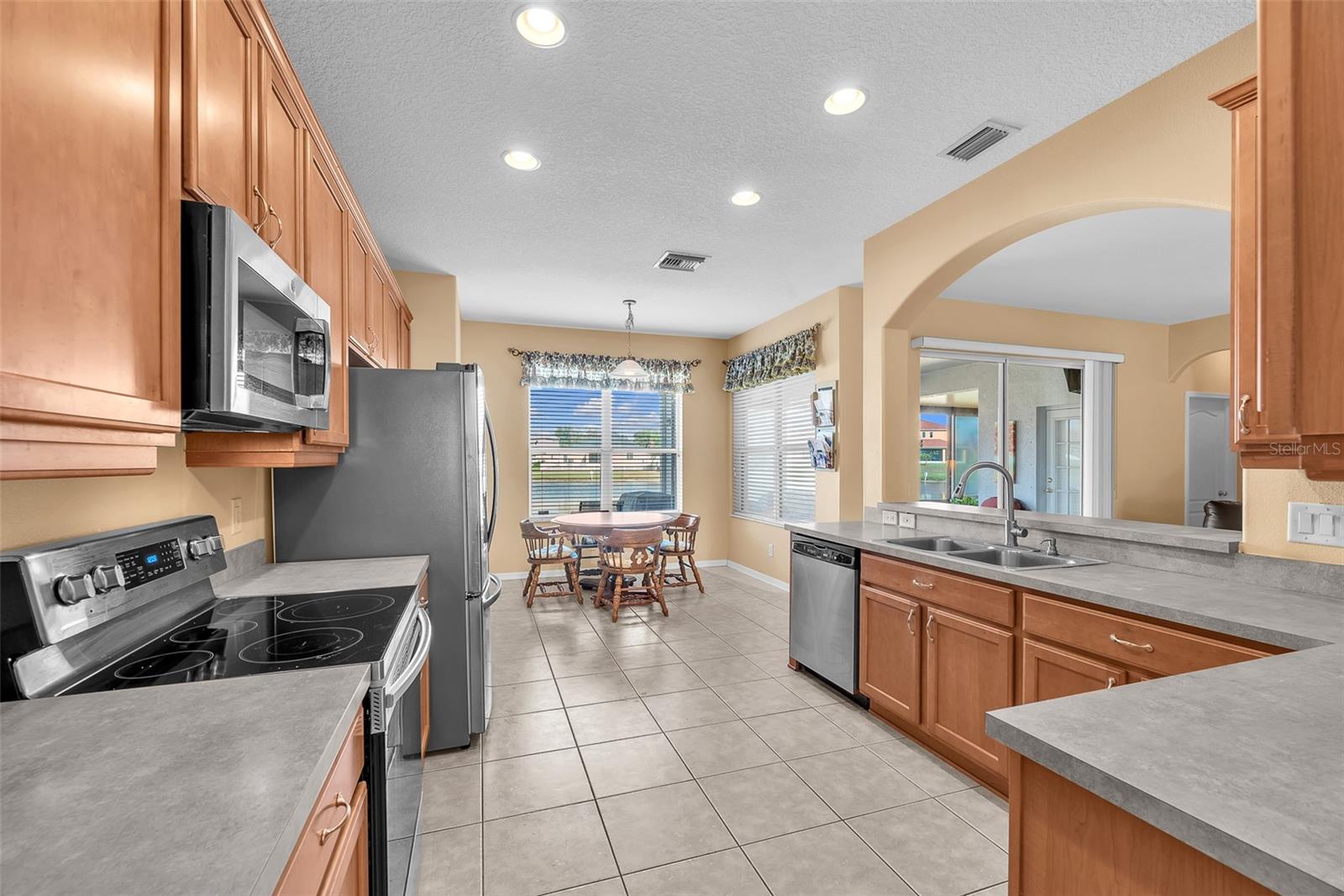 kitchen featuring extensive cabinetry, ample counter space, a sunny breakfast nook, and a convenient breakfast bar.