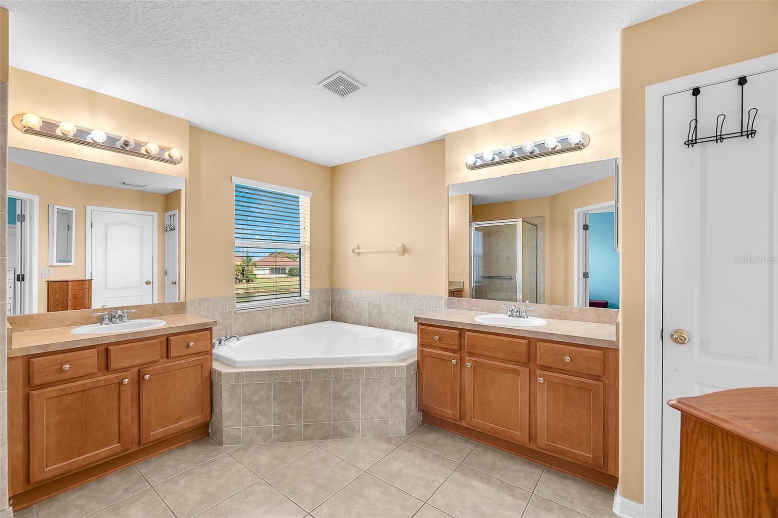 Main suite bathroom has split vanities and a 2 person tub