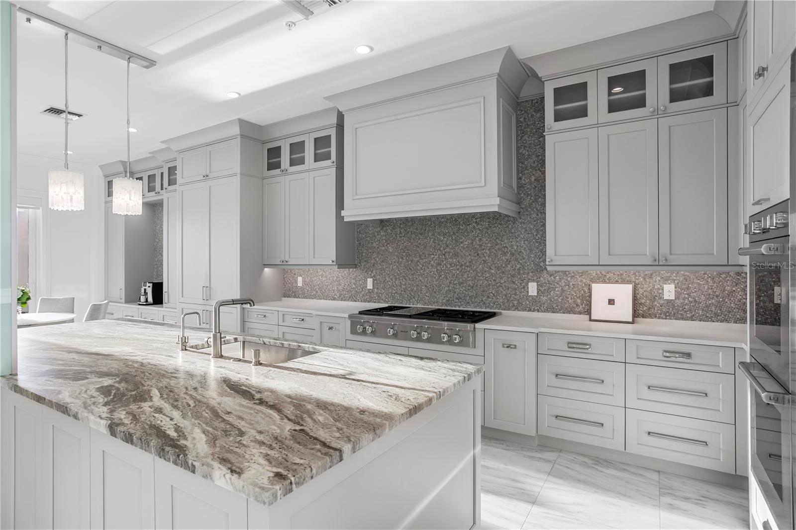 The chef's kitchen is a work of art, outfitted with double Wolf ovens, a Wolf six-burner gas cooktop, a and Sub-Zero 60" refrigerator