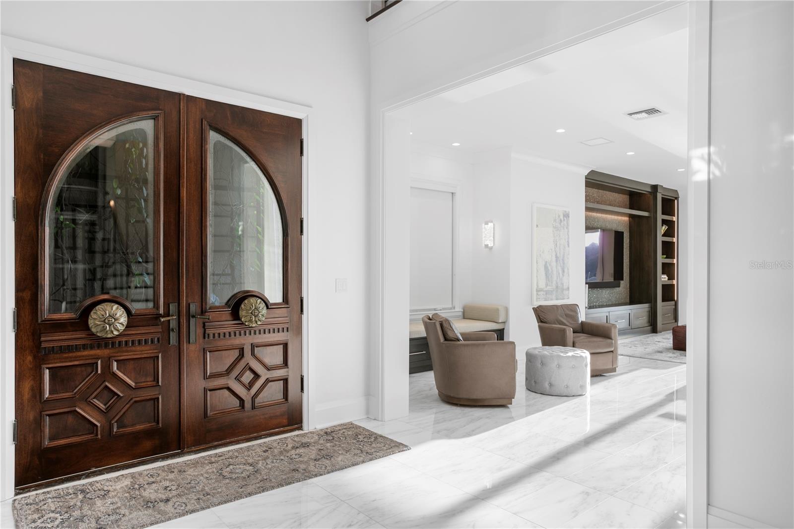 A set of double doors opens to a warm, inviting entryway and open concept living space
