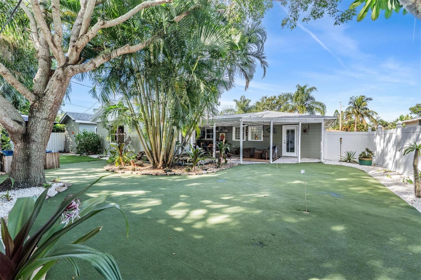 Low maintenance turf backyard with putting green