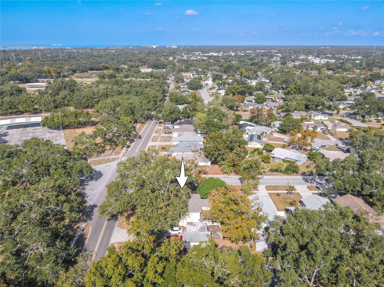 This north-facing aerial view provides a clear perspective of the home’s location within a quiet residential neighborhood. Highlighted with an arrow for easy identification, the property sits among mature trees and well-kept homes, offering a blend of privacy and community. The surrounding streets are lined with sidewalks, schools, and parks, showcasing the convenience and accessibility of this desirable area. A great overview of the property’s setting and neighborhood appeal.
