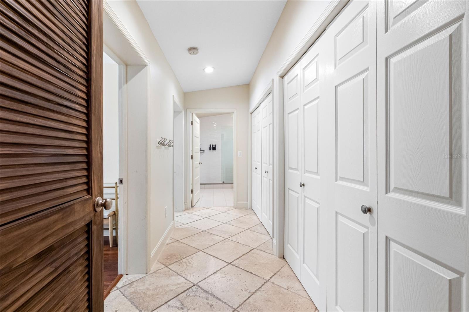 Hall to bedrooms with storage closets