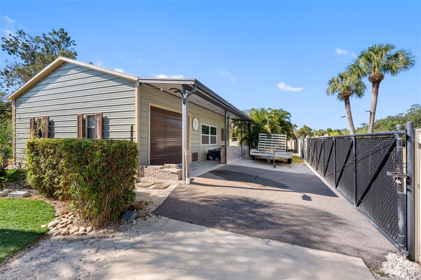 Rear of detached garage with sliding gate and sitting area
