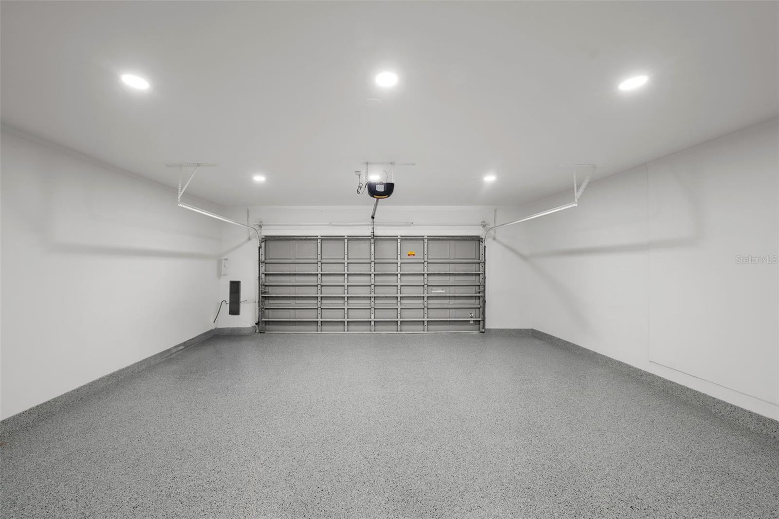 Fully updated garage featuring brand-new epoxy flooring and modern lighting.