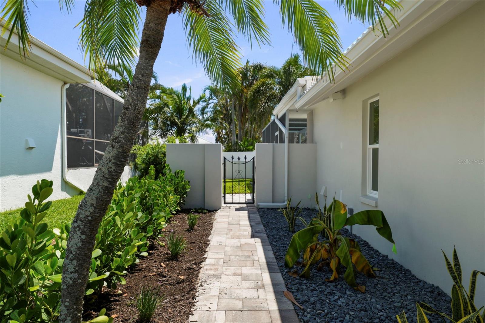 Newly paved shell stone walkway and fresh landscaping complimented with  granite rock designed to withstand mold and mildew