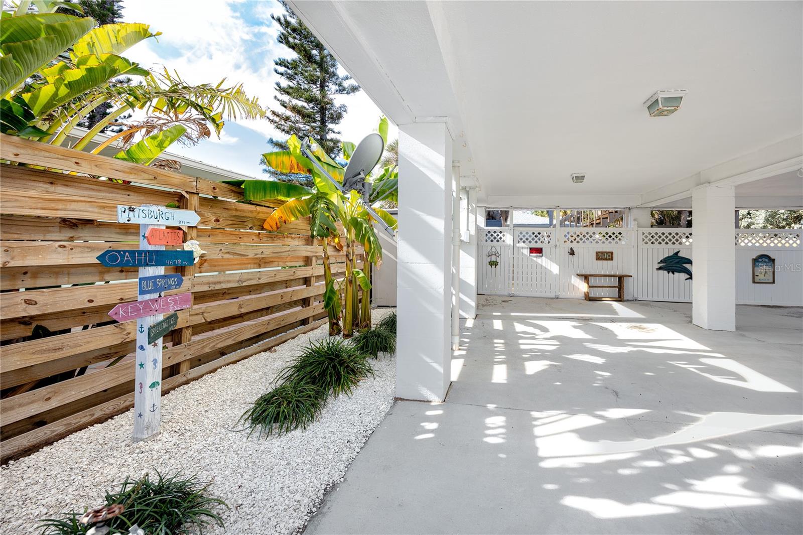 Freshly landscaped yard offering outdoor shower & additional shed under parking area.