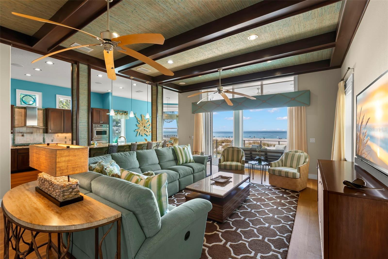 The Gathering Room is layered in texture from the wood floors to the beamed ceilings and grass cloth detail.