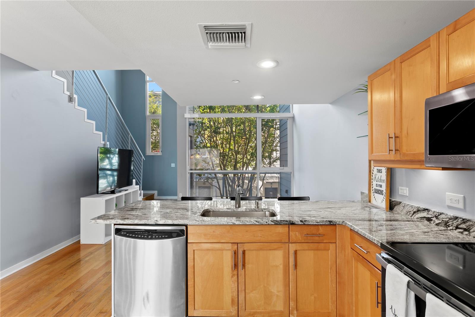 Main level (2nd) Chef's kitchen looking back to courtyard views and floor to ceiling windows