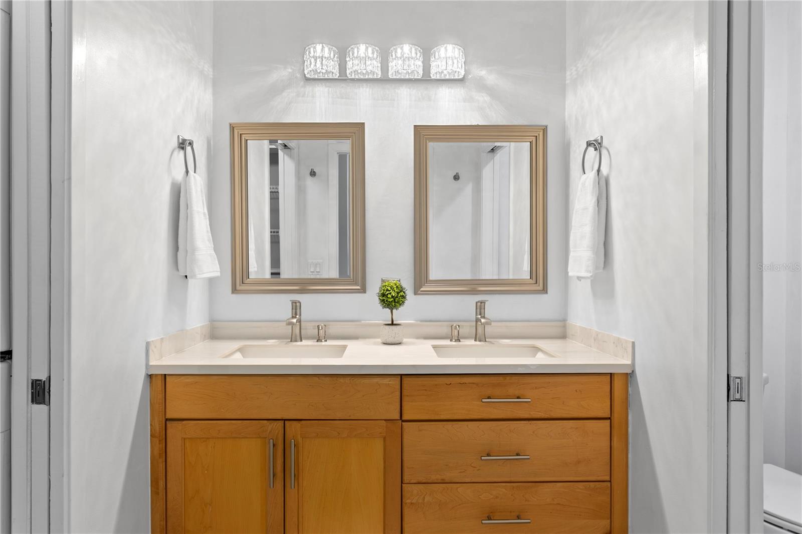 3rd floor Primary loft ensuite bath with newer stone double vanities, lighting and mirrors