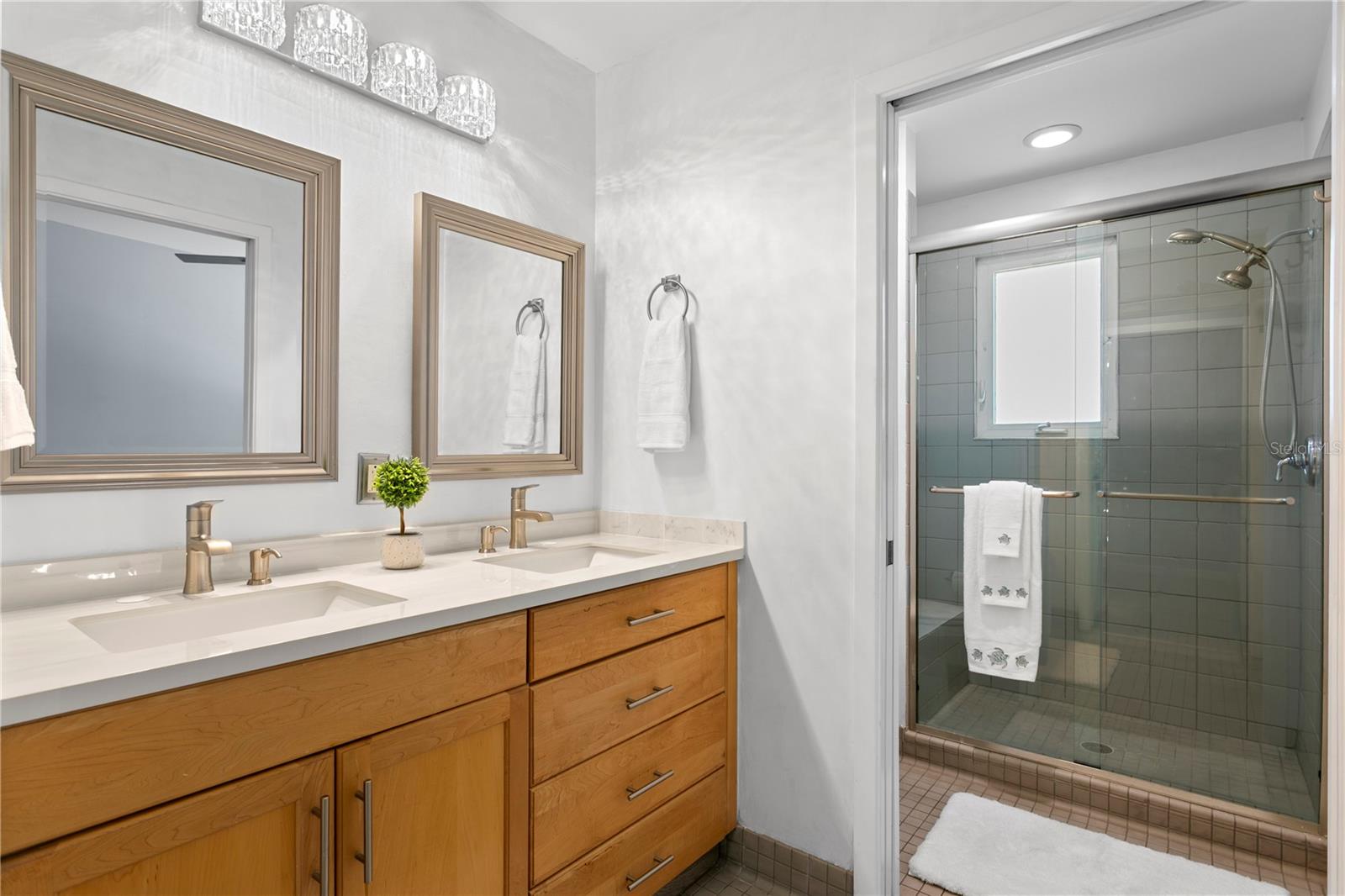 primary ensuite loft bath with newer stone counter, double vanities and a  walk in shower