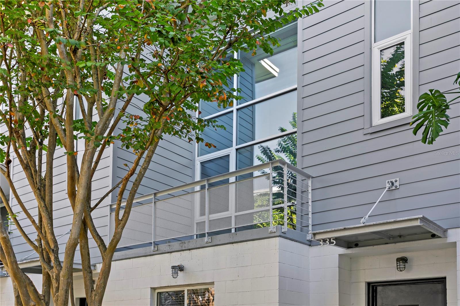 Exterior view of expansive floor to ceiling windows and private balcony off the living room