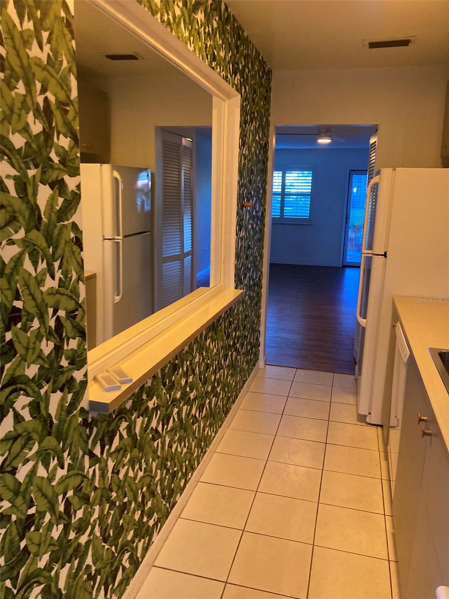 Kitchen has vibrant wallpaper and a large mirror.