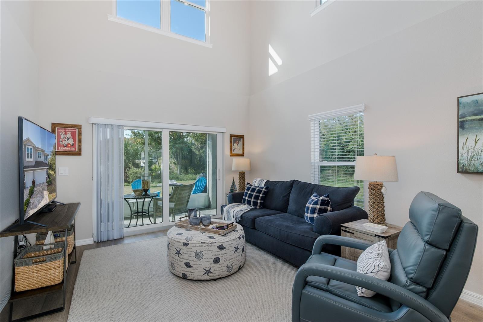 Living room looks out to screened lanai and back patio