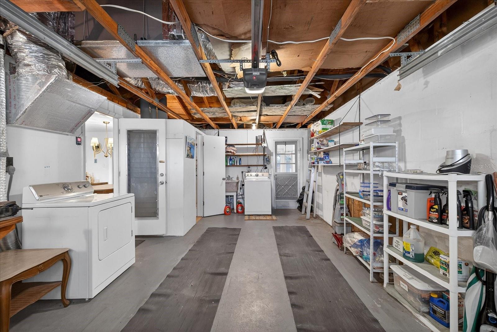 Garage with workbench/laudry washer dryer and bathroom with shower/toilet/laudry sink