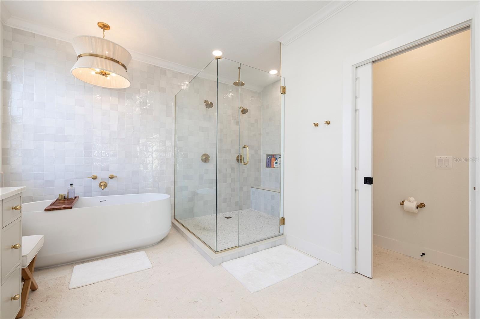 Primary Bathroom with dual faucets, limestone floors and custom cabinetry