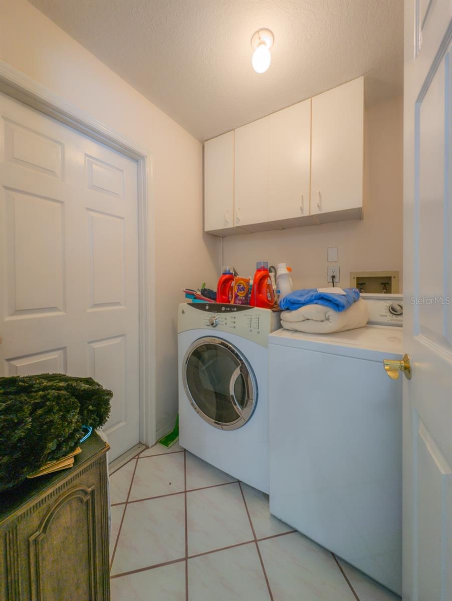 laundry room with cabinets door to garage