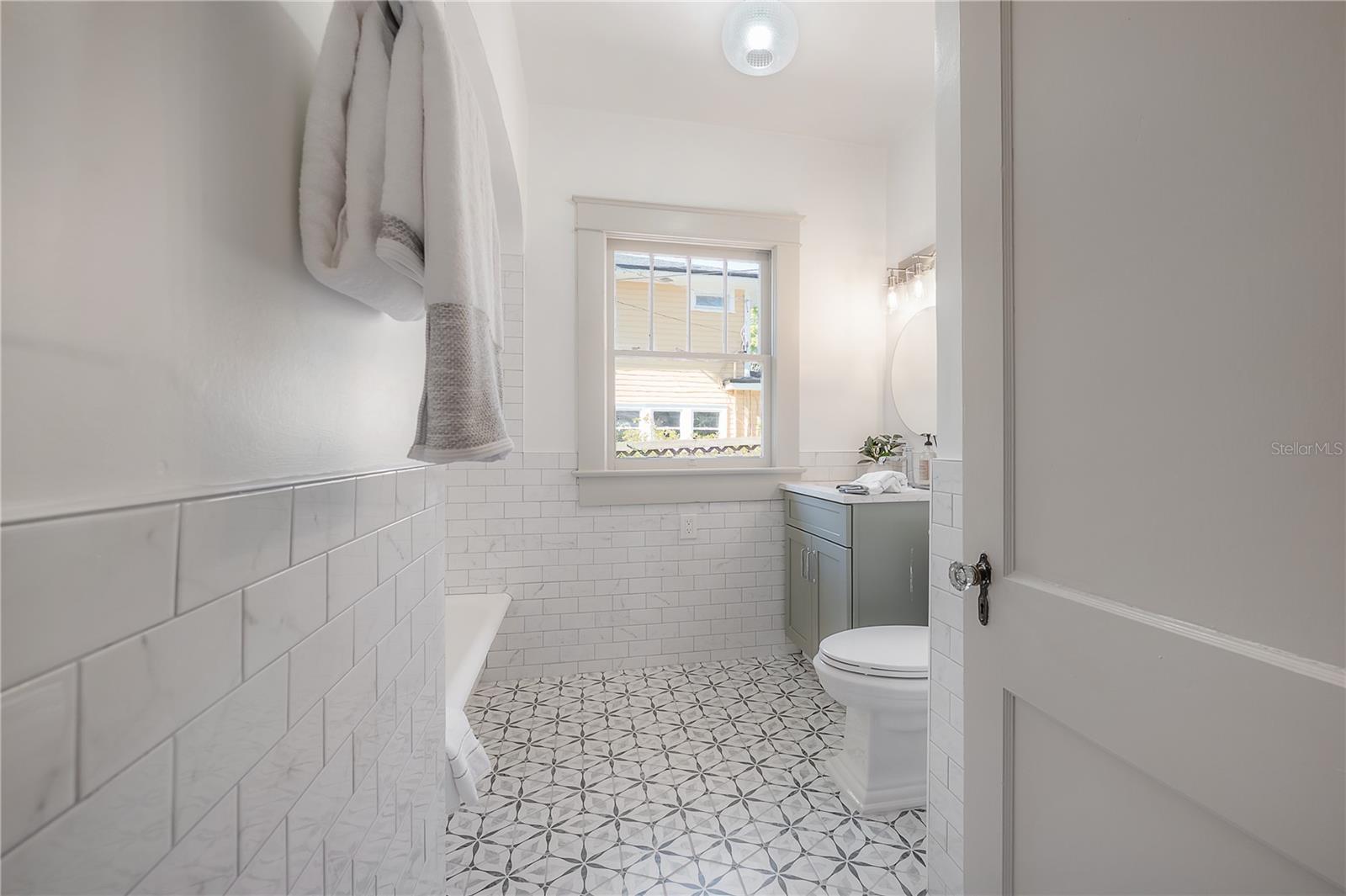 Hall bathroom with patterned tile flooring and great natural light