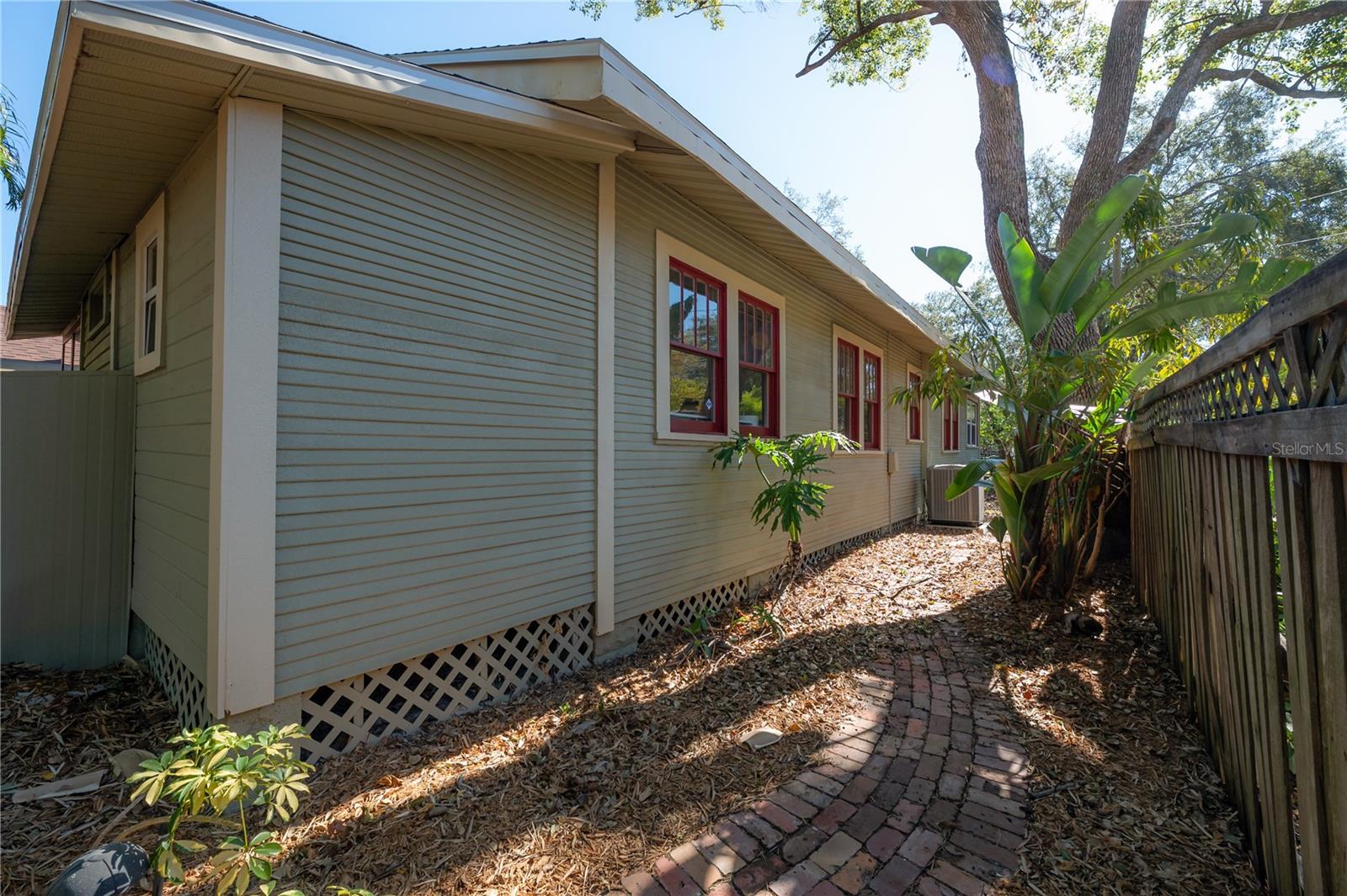 A charming brick walkway runs along the side of the home