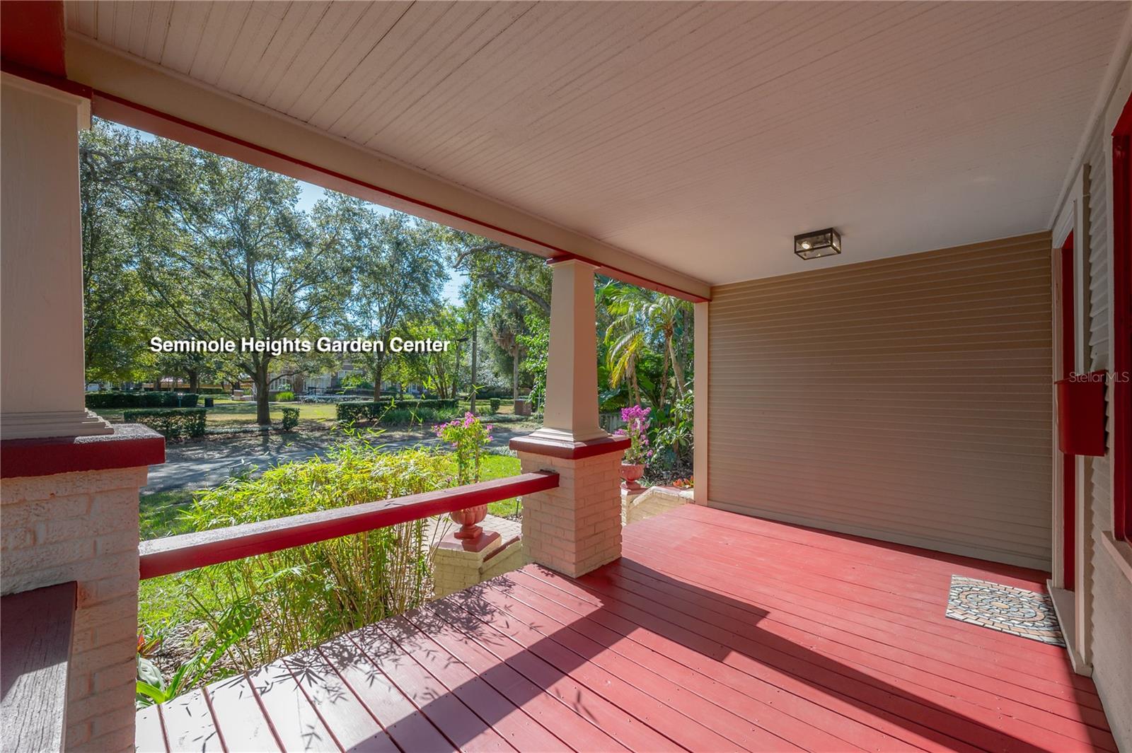 Covered front porch with original architectural details and garden views
