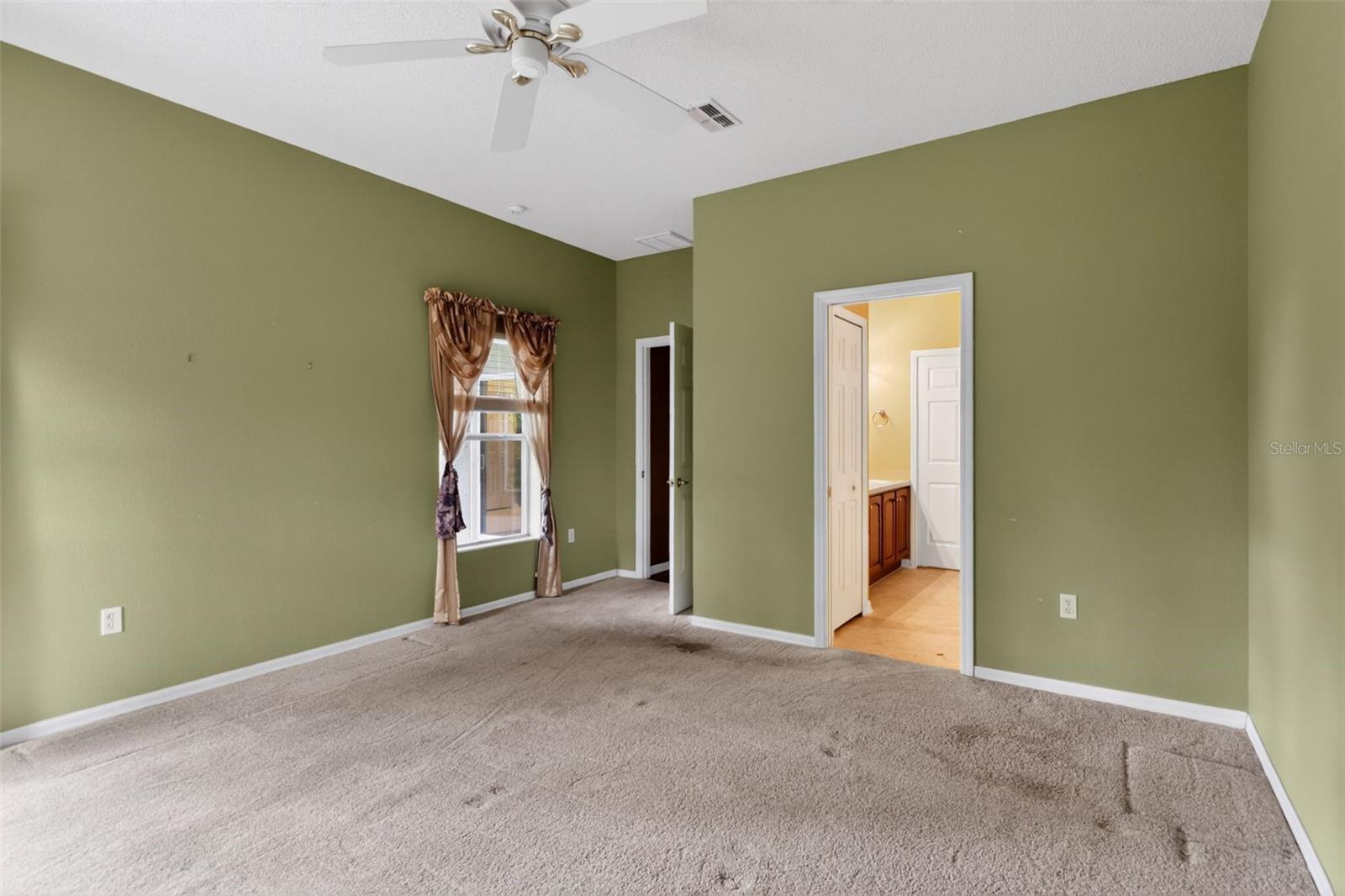 Large, primary bedroom with ceiling fan