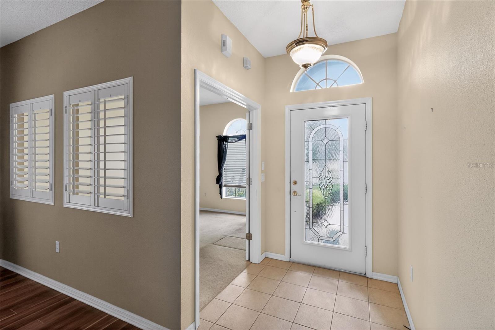 Well lit entryway with tile flooring leading into the home