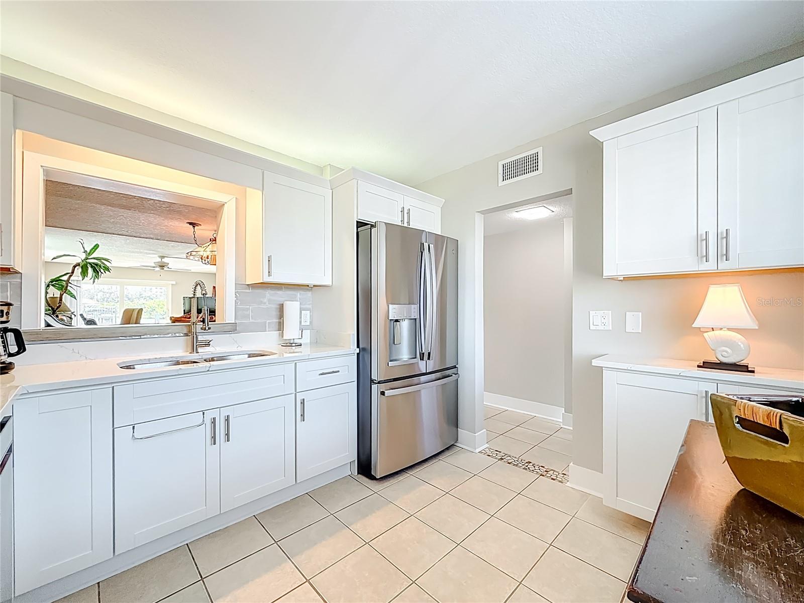 The kitchen overlooks the living area with views of the water.  The newer kitchen is the perfect complement to this waterfront condo's freash and inviting feel.