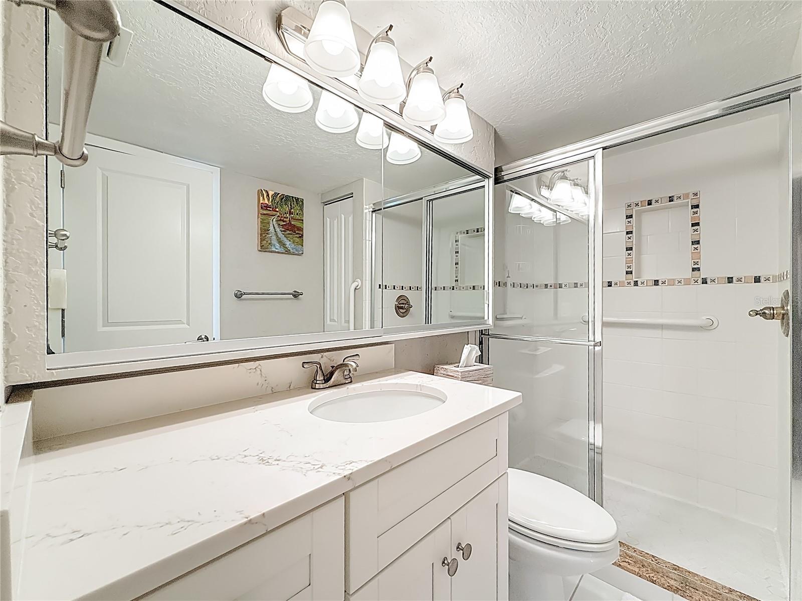 The primary bathroom has a newer vanity with quartz countertop & additional space on the counter, which is so nice to have.