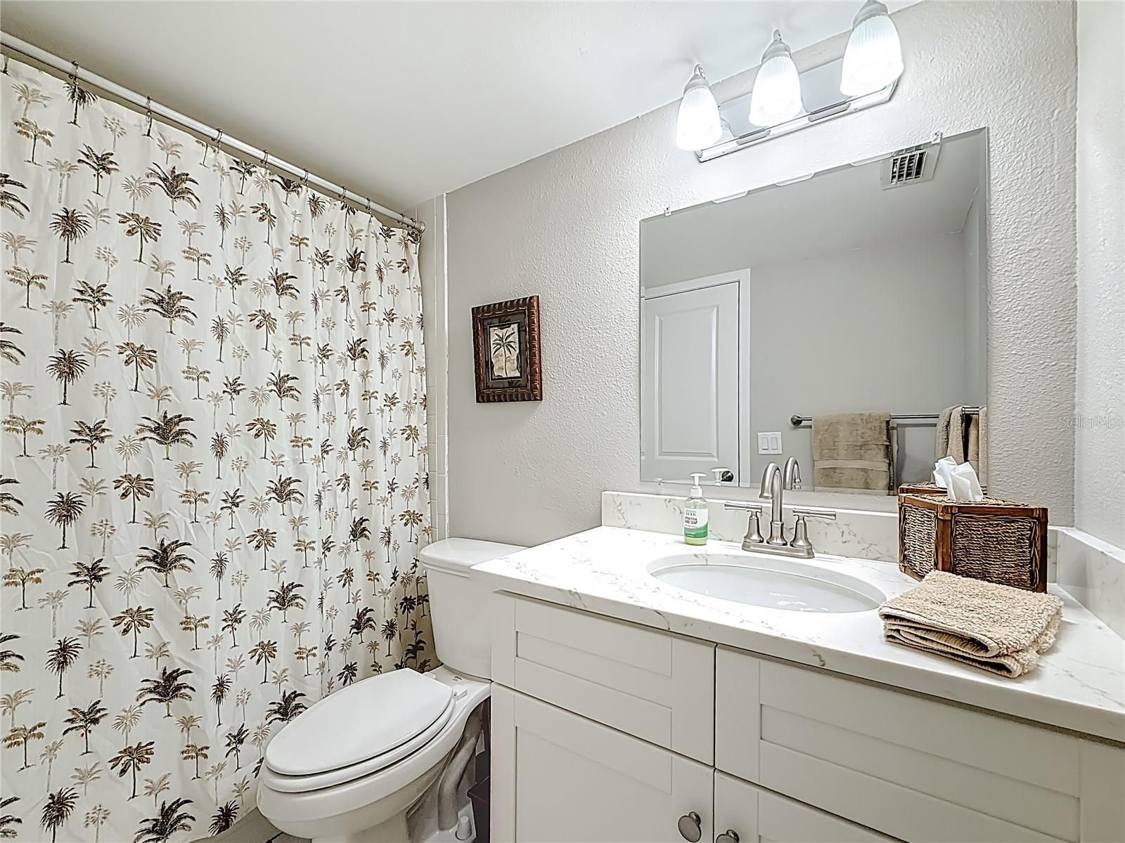 Guest bathroom that is nicely decorated with a quartz countertop that offers additional space.