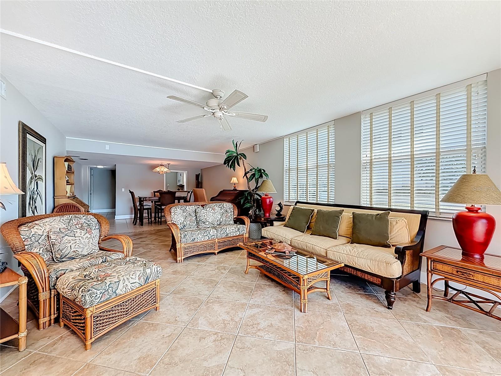 This bright expansive living area offers a stunning wall of hurricane impact windows that fill the space with natural light and peaceful water views.
