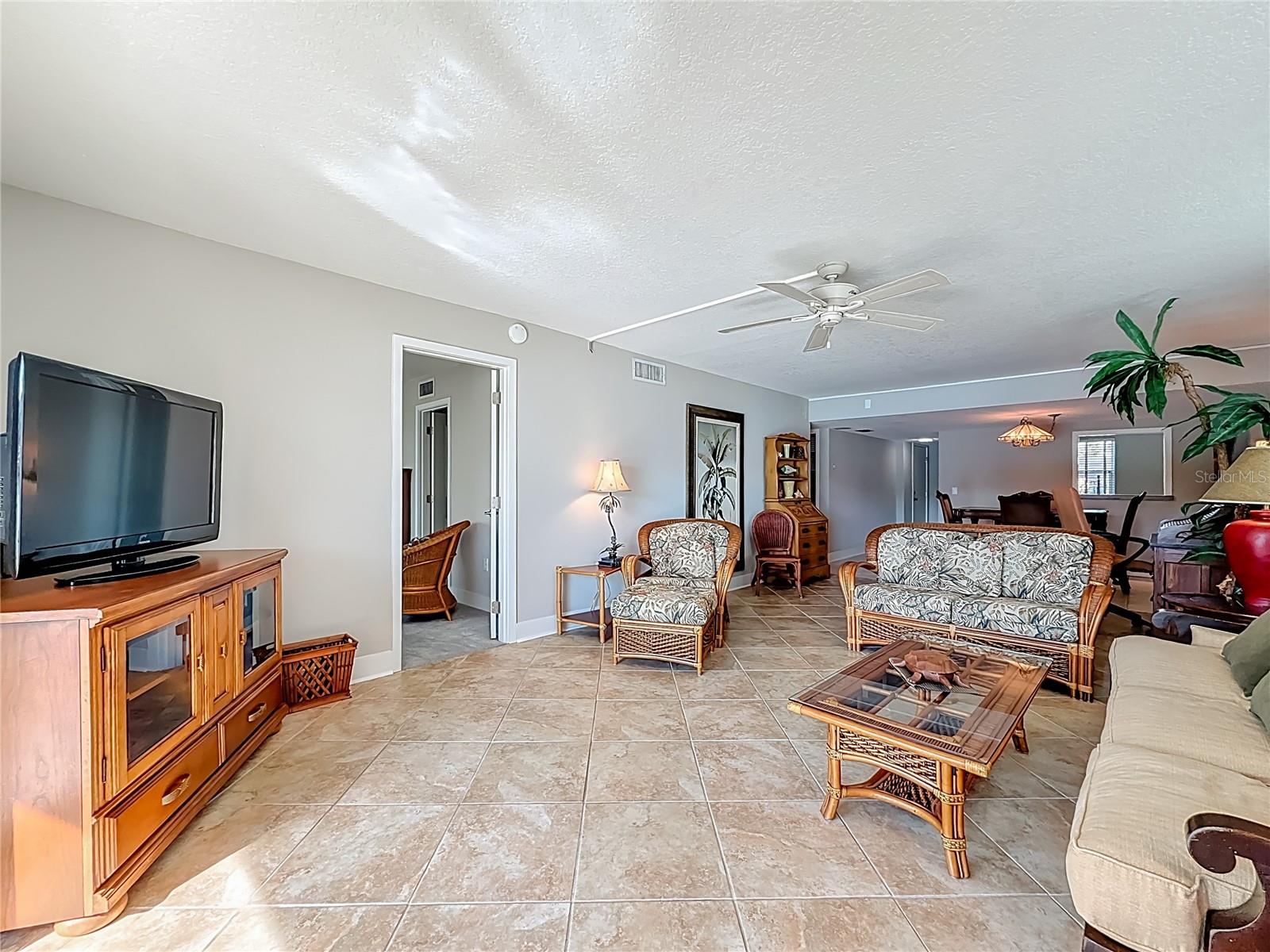The flooring throughout the living area keeps the home cool & coastal, while the spacious design highlights the condo's generous square footage & inviting ambiance.
