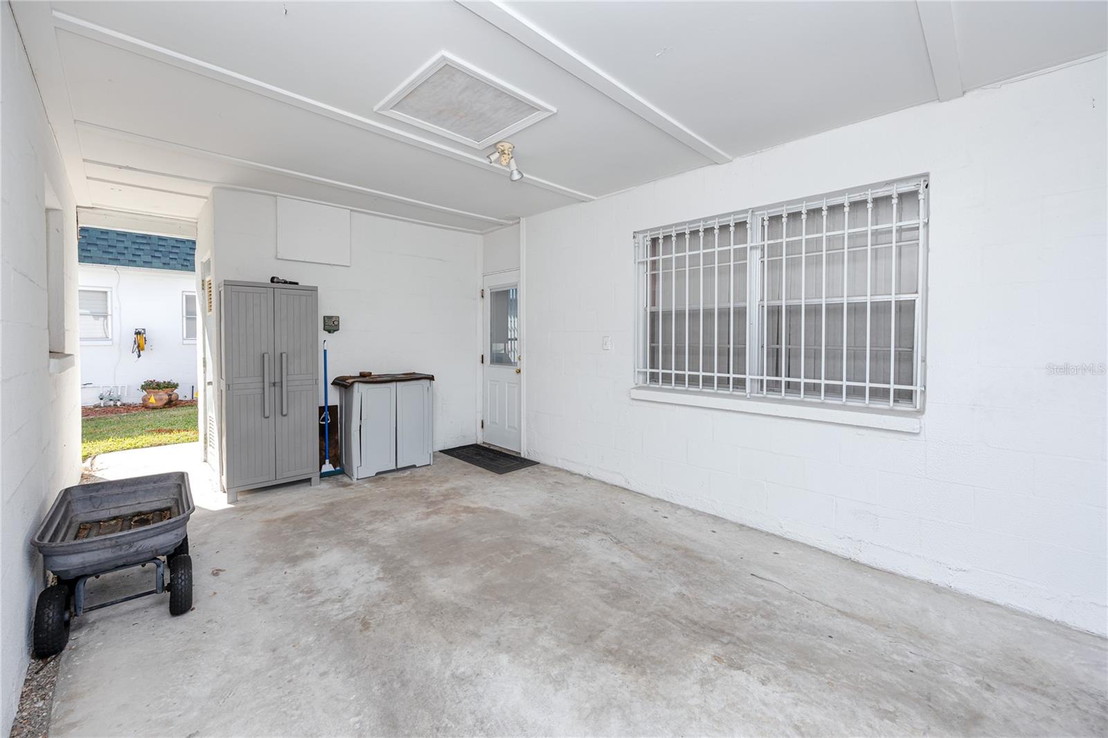 Covered carport with entrance at front and rear.